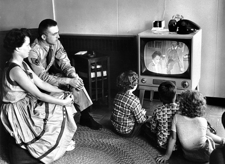 A United States serviceman views television with his family at the U.S. Limestone, Maine, base on July 1, 1954. Nearly every household in the United States has at least one televison set and viewers have their sets on an average of seven hours daily. Television, the tool of mass communications, gave birth to cable television, encompassing time and thought as no other cultural phenomenon ever has. (AP Photo)